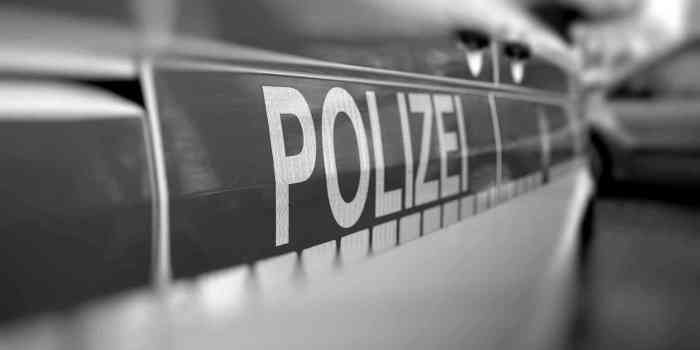 Großaufnahme Aufschrift "Polizei" auf Einsatzfahrzeug bei einer Durchsuchung